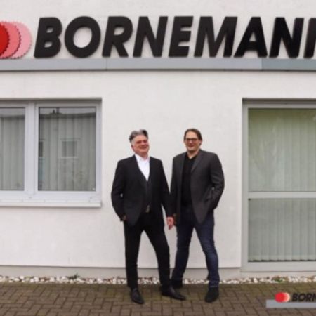 two men in suits in front of the bornemann headquarters