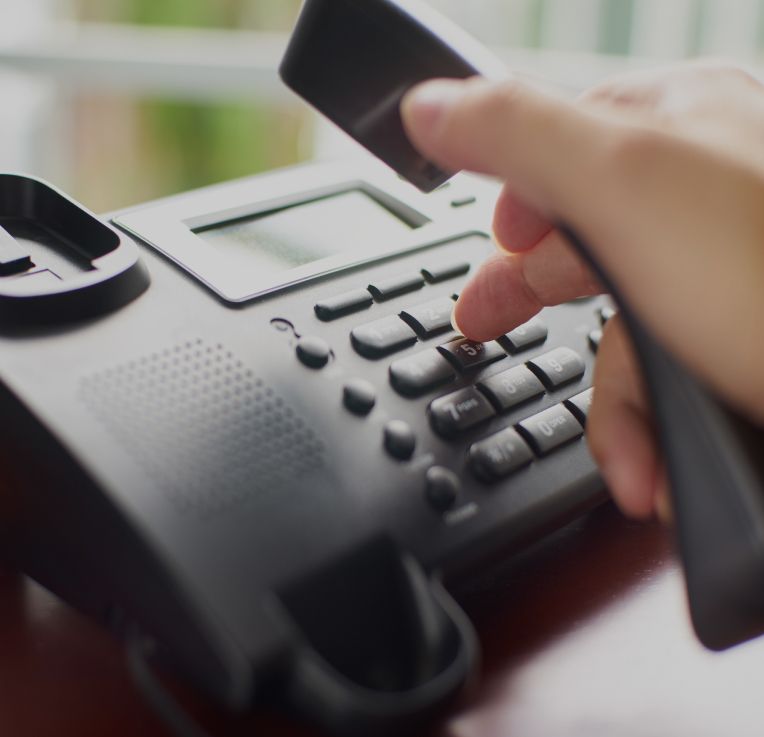 hand dialing a number in a stationary telephone